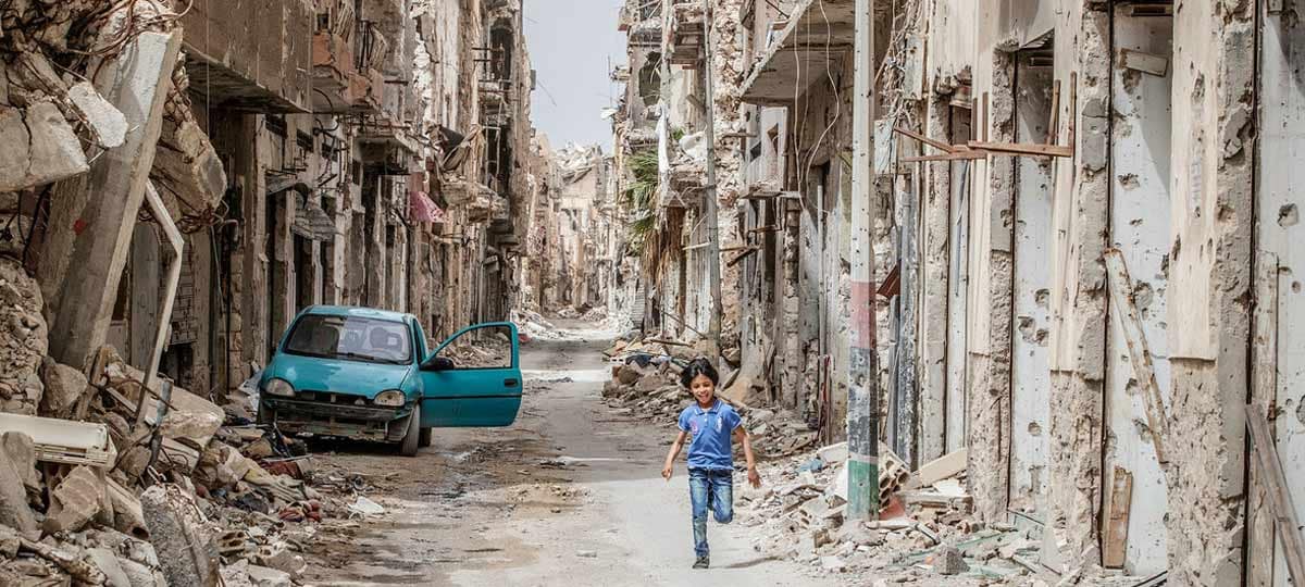 A child runs through the ruins of Benghazi, Libya.