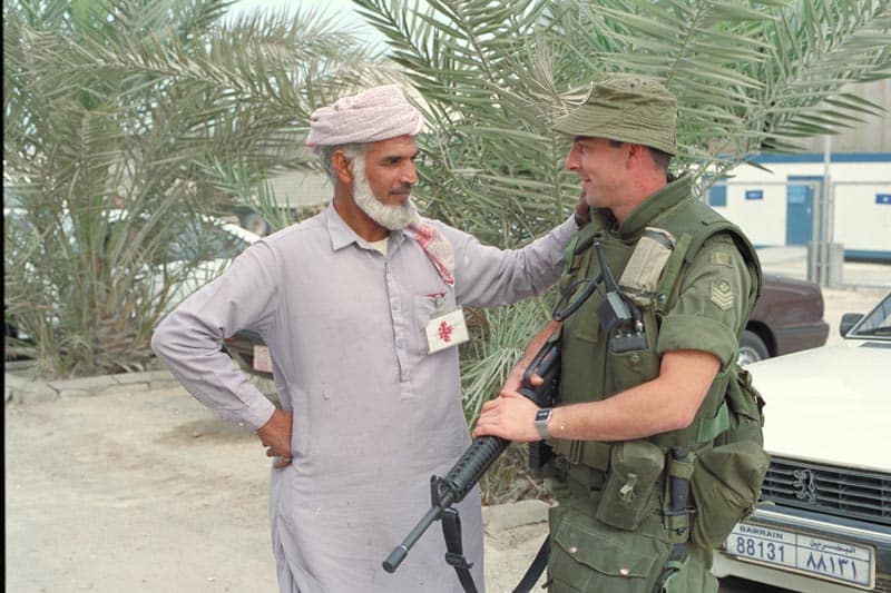 Sergeant Dan Potvin chats with a civilian while on sentry duty at the Canadian military headquarters in Bahrain. January 13, 1991.